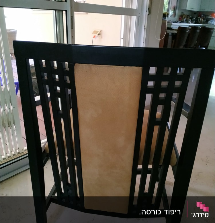 כיסא עם ריפוד חום במסגרת עץ שחורה